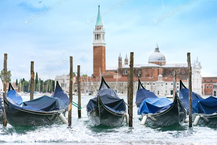 چند قایق که روبروی کلیسایی در ونیز،ایتالیا در آب به چوب بسته شده‌اند