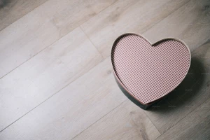 تصویر یک جعبه قلبی بر‌روی میز چوبی