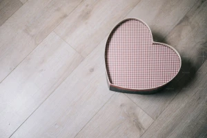 جعبه به شکل قلب رنگی روی میز چوبی