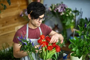 مرد گلفروش در حال مرتب کردن یک دسته گل