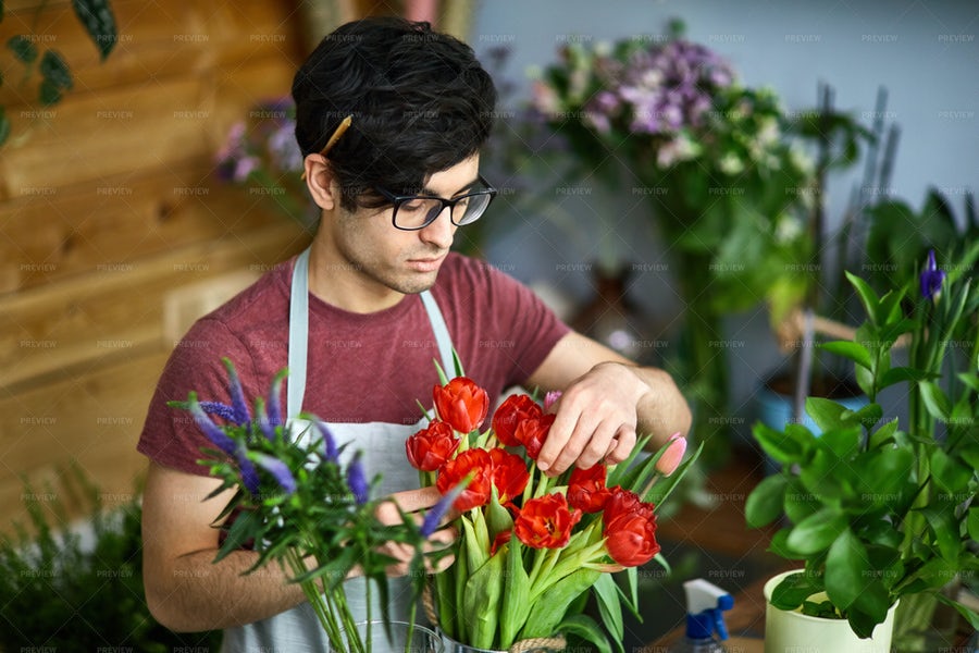 مرد گلفروش در حال مرتب کردن یک دسته گل