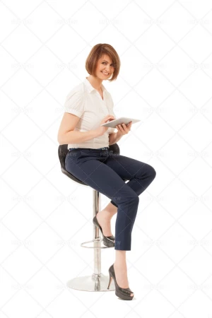 خانمی که روی صندلی نشسته و درحال کار با تبلت با پس زمینه سفید