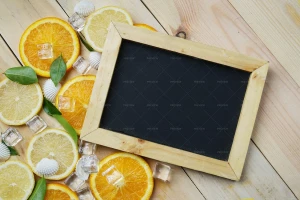 تخته سیاه خالی بر روی یک میز چوبی در کنار تکه های میوه