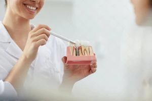 خانم دندانپزشک خندان در حال تشریح ساختار دندان