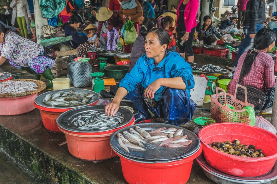 یک خانم در حال فروش ماهی تازه در بازار تایلند