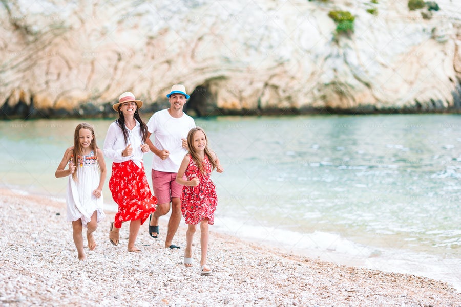 یک خانواده خوشحال در حال دویدن در کنار ساحل