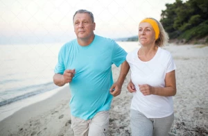 زوج میانسال در حال دویدن در کنار ساحل