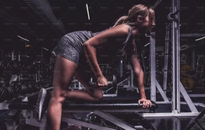 یک خانوم درحال استفاده از وزنه در باشگاه برای افزایش قدرت عضلات