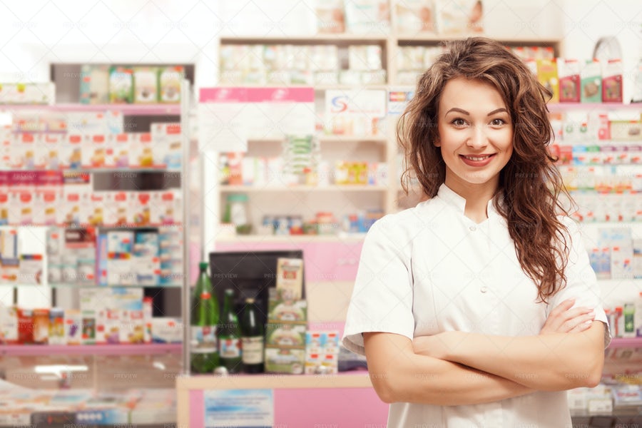 کارمند داروخانه خندان در کنار محصولات دارویی و بهداشتی