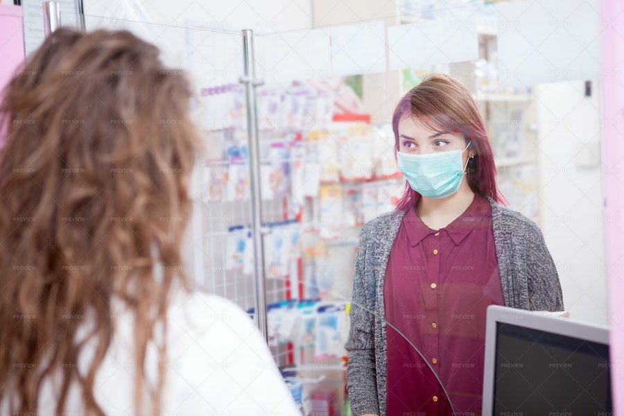 یک مشتری در داروخانه که به خاطر ویروس کرونا ماسک به صورت زده