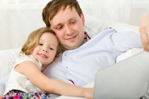 پدر و دختر خوشحال در حال کار با لپ تاپ