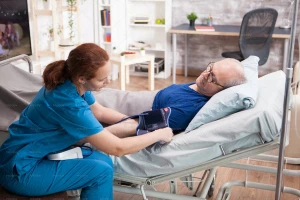 خانوم پرستار در‌حال بررسی فشار خون یک مرد مسن