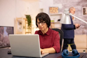 یک زن میانسال درحال کار با لپ تاپ