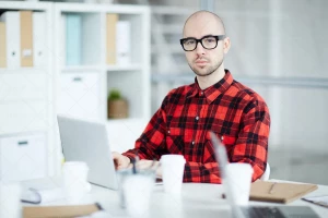 مردی در حال کار با لپ تاپ در شرکت