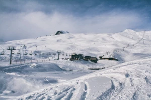 تصویر یک کلبه اسکی در دامنه های پوشیده از برف