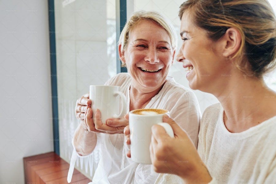 دو خانم در حال نوشیدن قهوه و خندیدن