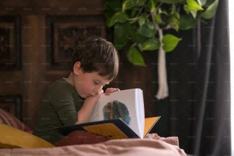 تصویر پسر بچه در حال کتاب خواندن